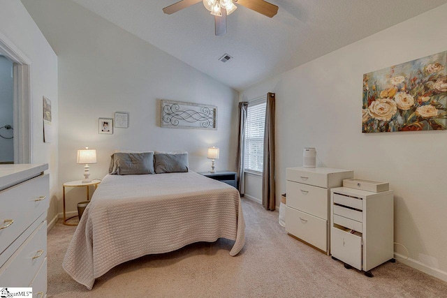 bedroom featuring ceiling fan, light colored carpet, visible vents, baseboards, and vaulted ceiling