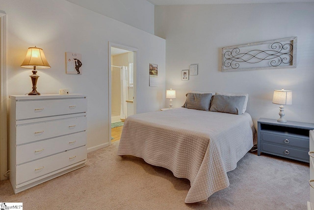 bedroom with light carpet and ensuite bath