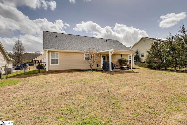 back of house featuring a yard and fence