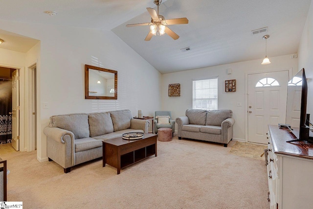 living room featuring light carpet, ceiling fan, visible vents, and vaulted ceiling