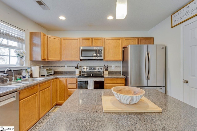 kitchen featuring tasteful backsplash, visible vents, stainless steel appliances, a sink, and recessed lighting