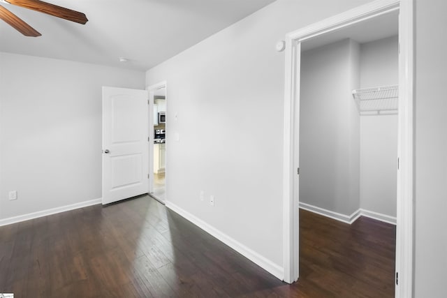 interior space featuring a ceiling fan, baseboards, and wood finished floors