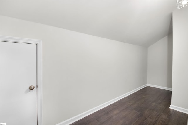 additional living space featuring lofted ceiling, visible vents, dark wood finished floors, and baseboards