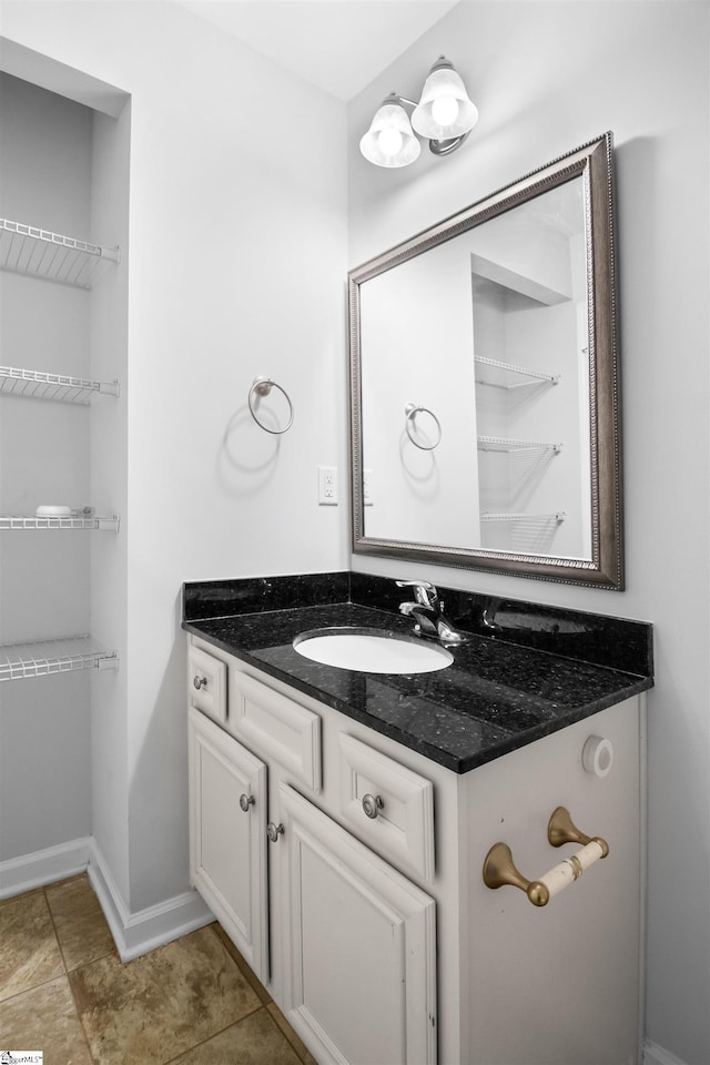 bathroom with vanity, baseboards, and tile patterned floors