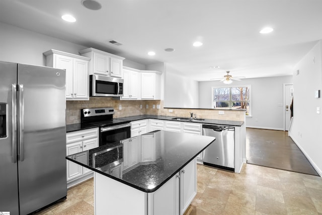 kitchen featuring a peninsula, a sink, visible vents, white cabinets, and appliances with stainless steel finishes