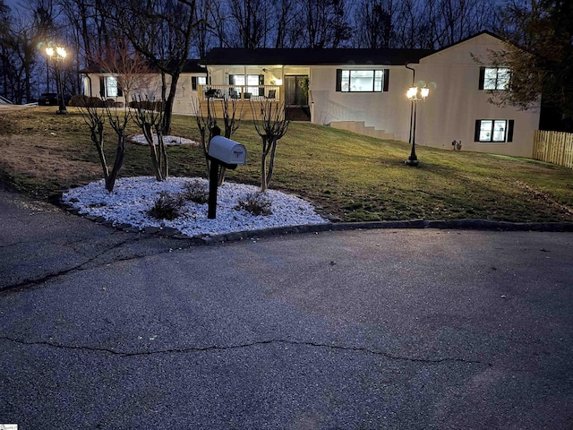 view of front of property with a front lawn, fence, and stucco siding