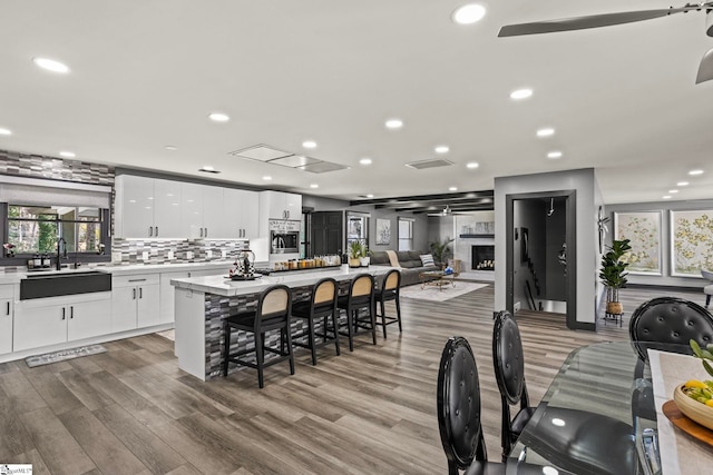 kitchen featuring a kitchen bar, a sink, a wealth of natural light, and a center island