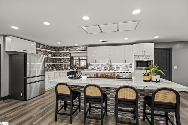 kitchen featuring stainless steel appliances, recessed lighting, tasteful backsplash, dark wood-type flooring, and white cabinets