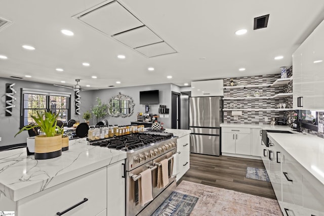 kitchen featuring open shelves, visible vents, decorative backsplash, appliances with stainless steel finishes, and white cabinets