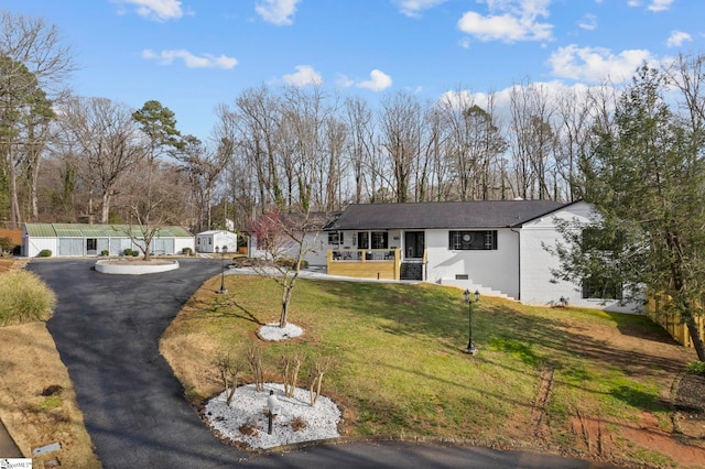 view of front of property featuring covered porch, a front yard, fence, and a garage