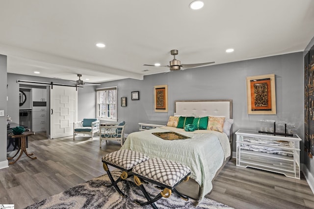 bedroom featuring recessed lighting, a barn door, a ceiling fan, wood finished floors, and baseboards