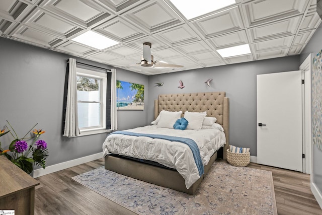 bedroom featuring an ornate ceiling, ceiling fan, baseboards, and wood finished floors