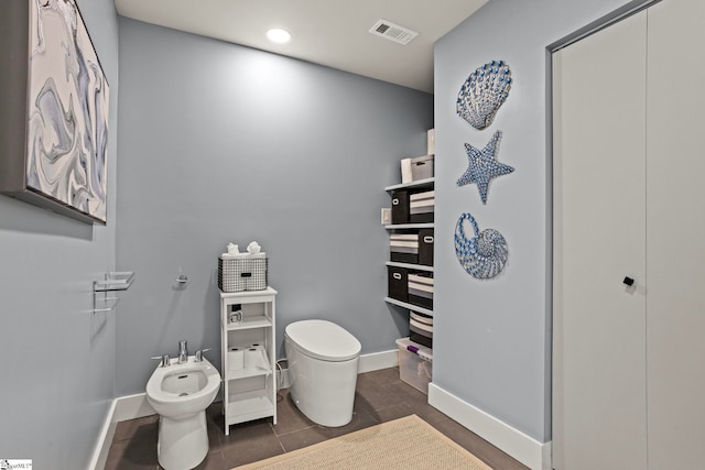 bathroom featuring tile patterned flooring, toilet, visible vents, baseboards, and a bidet