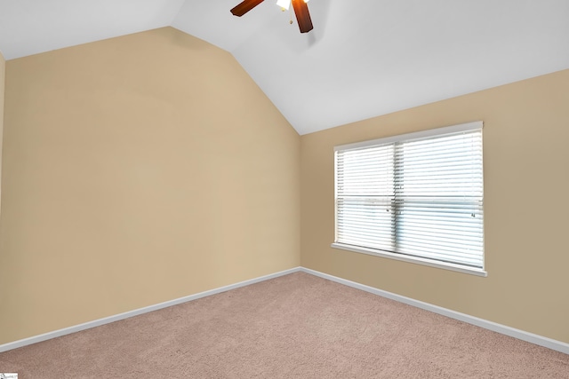 empty room featuring a ceiling fan, lofted ceiling, carpet flooring, and baseboards