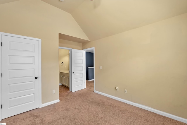 unfurnished bedroom with carpet floors, connected bathroom, vaulted ceiling, and baseboards