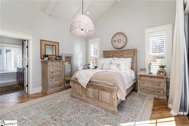 bedroom with high vaulted ceiling, light wood finished floors, and multiple windows