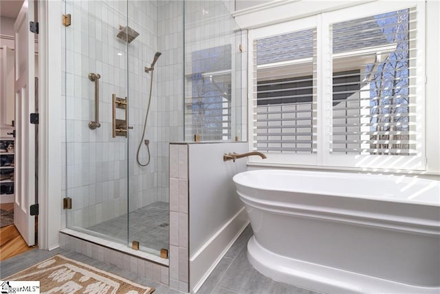 bathroom with a stall shower, a freestanding tub, and tile patterned floors