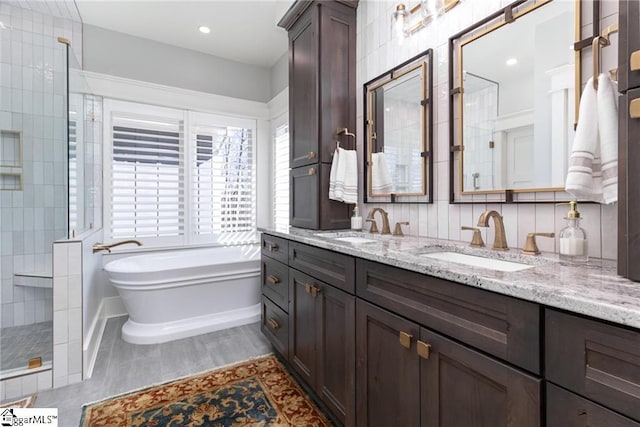 bathroom with a freestanding tub, double vanity, a sink, and a walk in shower