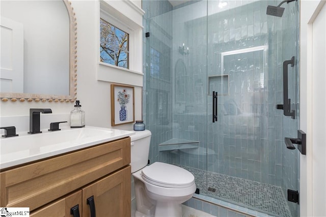 bathroom featuring a stall shower, vanity, and toilet