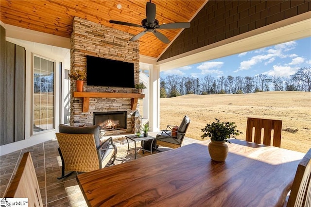 view of patio with ceiling fan and an outdoor stone fireplace