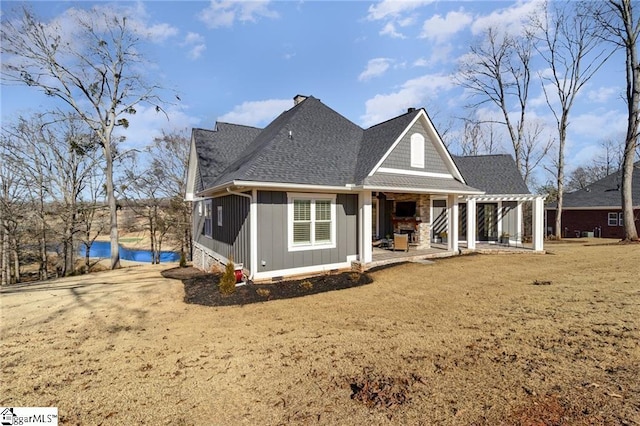 back of house with a shingled roof, board and batten siding, and a patio area