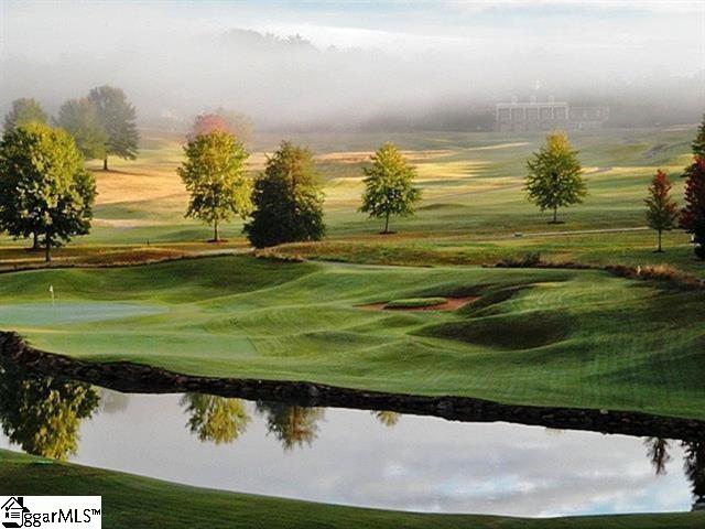 view of home's community with view of golf course, a yard, and a water view