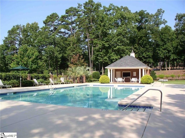 pool featuring an outbuilding and a patio