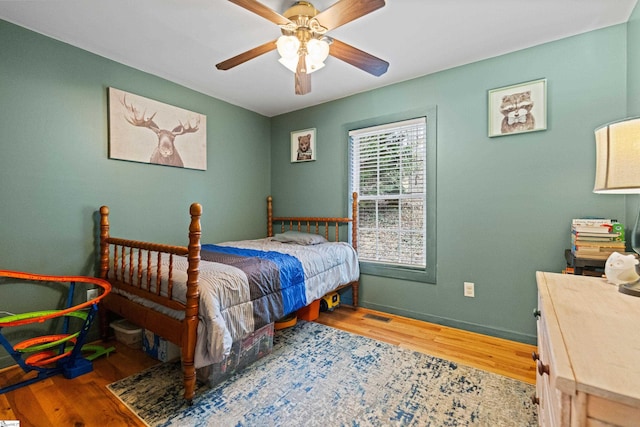 bedroom with visible vents, ceiling fan, baseboards, and wood finished floors