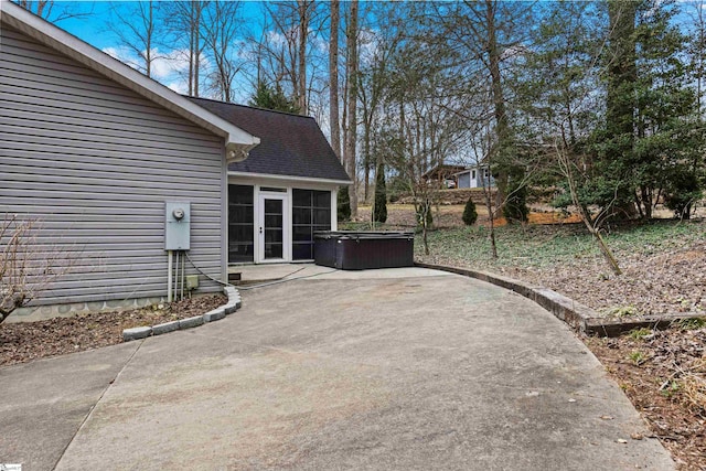 view of patio featuring a sunroom and a hot tub