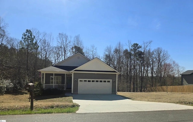 view of front of home featuring a garage, driveway, covered porch, and fence