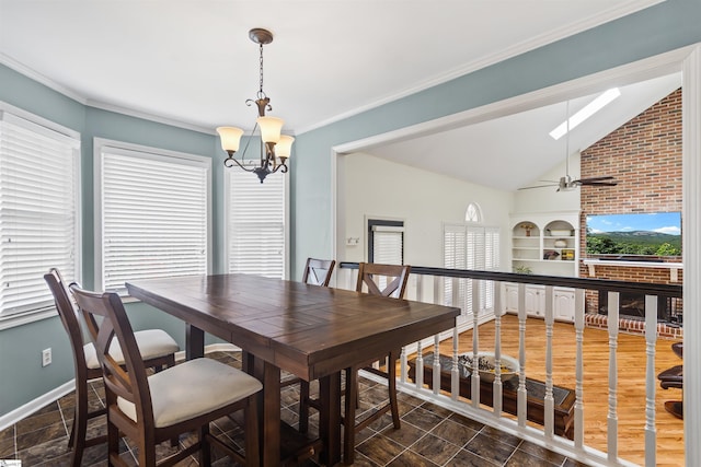 dining room with built in features, vaulted ceiling with skylight, baseboards, and ceiling fan with notable chandelier