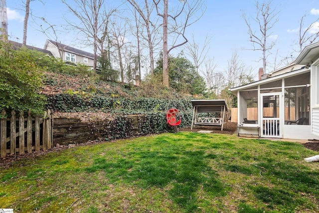 view of yard featuring a sunroom and fence