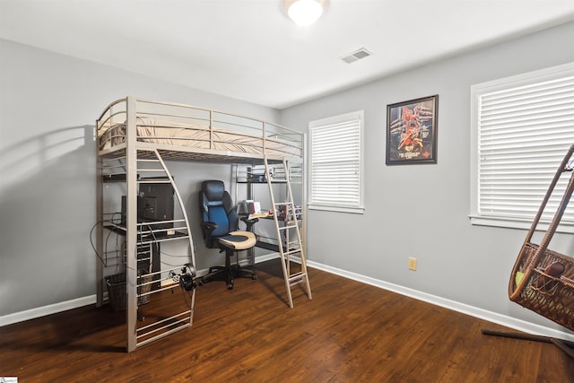 bedroom featuring baseboards, visible vents, and wood finished floors