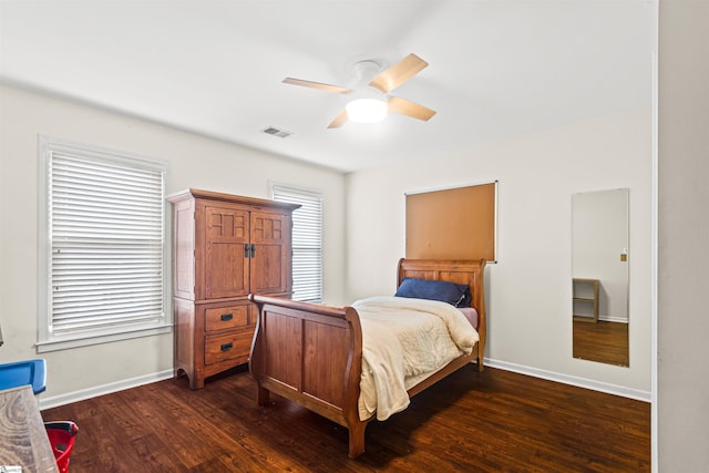 bedroom with a ceiling fan, dark wood-style flooring, visible vents, and baseboards