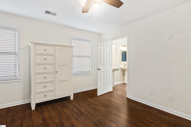 unfurnished bedroom featuring dark wood-style floors, visible vents, and baseboards