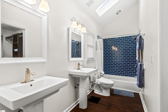 full bathroom with toilet, wood finished floors, a sink, visible vents, and vaulted ceiling