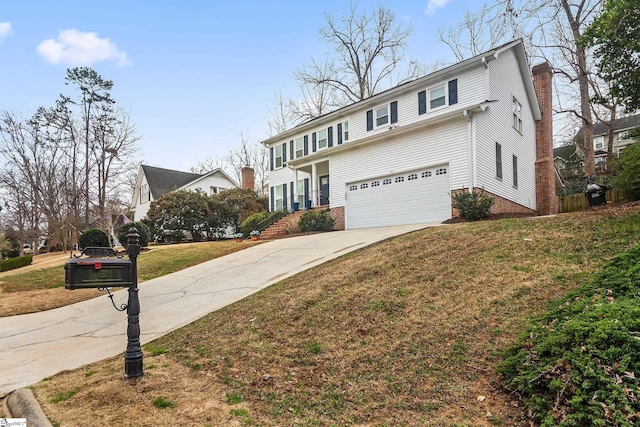 traditional home with a garage, a front yard, driveway, and a chimney