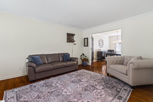 living room featuring baseboards, a notable chandelier, ornamental molding, and wood finished floors