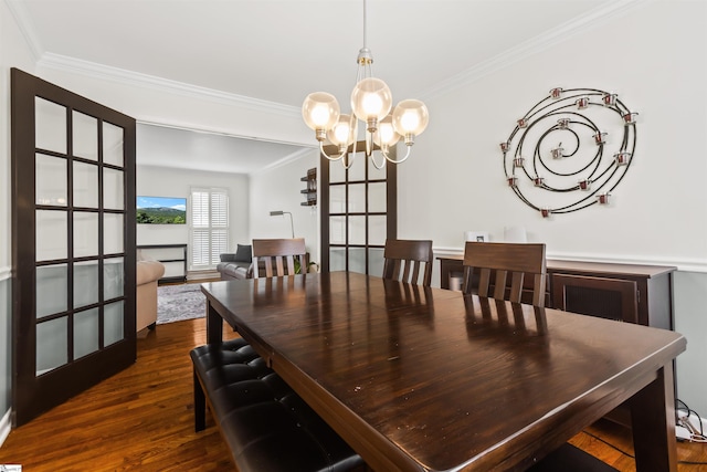 dining space featuring ornamental molding, dark wood-type flooring, and a notable chandelier