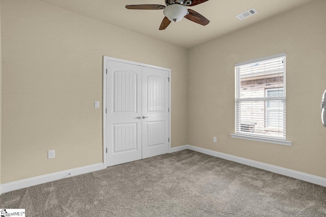 unfurnished bedroom with ceiling fan, visible vents, baseboards, a closet, and carpet