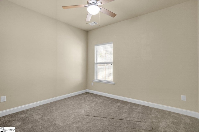 carpeted empty room with baseboards, visible vents, and a ceiling fan