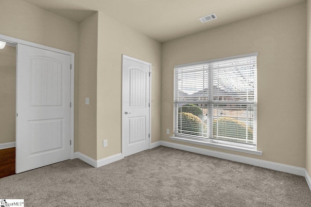 unfurnished bedroom featuring carpet floors, visible vents, and baseboards