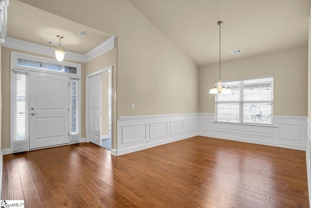 entrance foyer with dark wood-style floors, visible vents, wainscoting, vaulted ceiling, and a chandelier