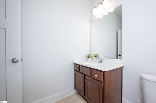 bathroom with toilet, baseboards, and vanity