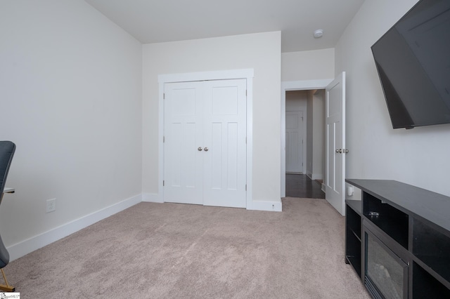 bedroom featuring light carpet and baseboards