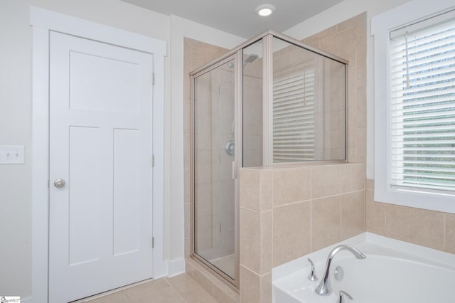 bathroom featuring a garden tub, a shower stall, and tile patterned floors