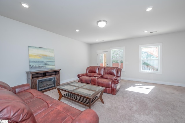 living room with recessed lighting, visible vents, a glass covered fireplace, light carpet, and baseboards