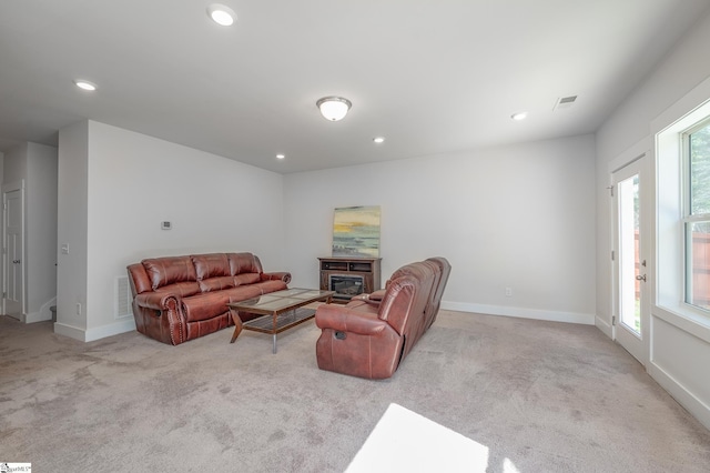 living room featuring recessed lighting, carpet floors, visible vents, baseboards, and a glass covered fireplace