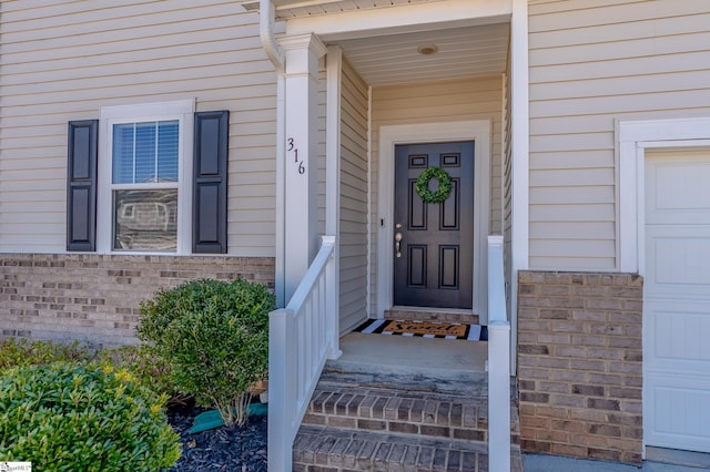 doorway to property with brick siding