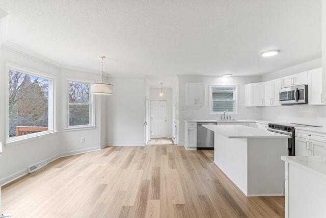 kitchen with light countertops, visible vents, appliances with stainless steel finishes, white cabinetry, and light wood-type flooring